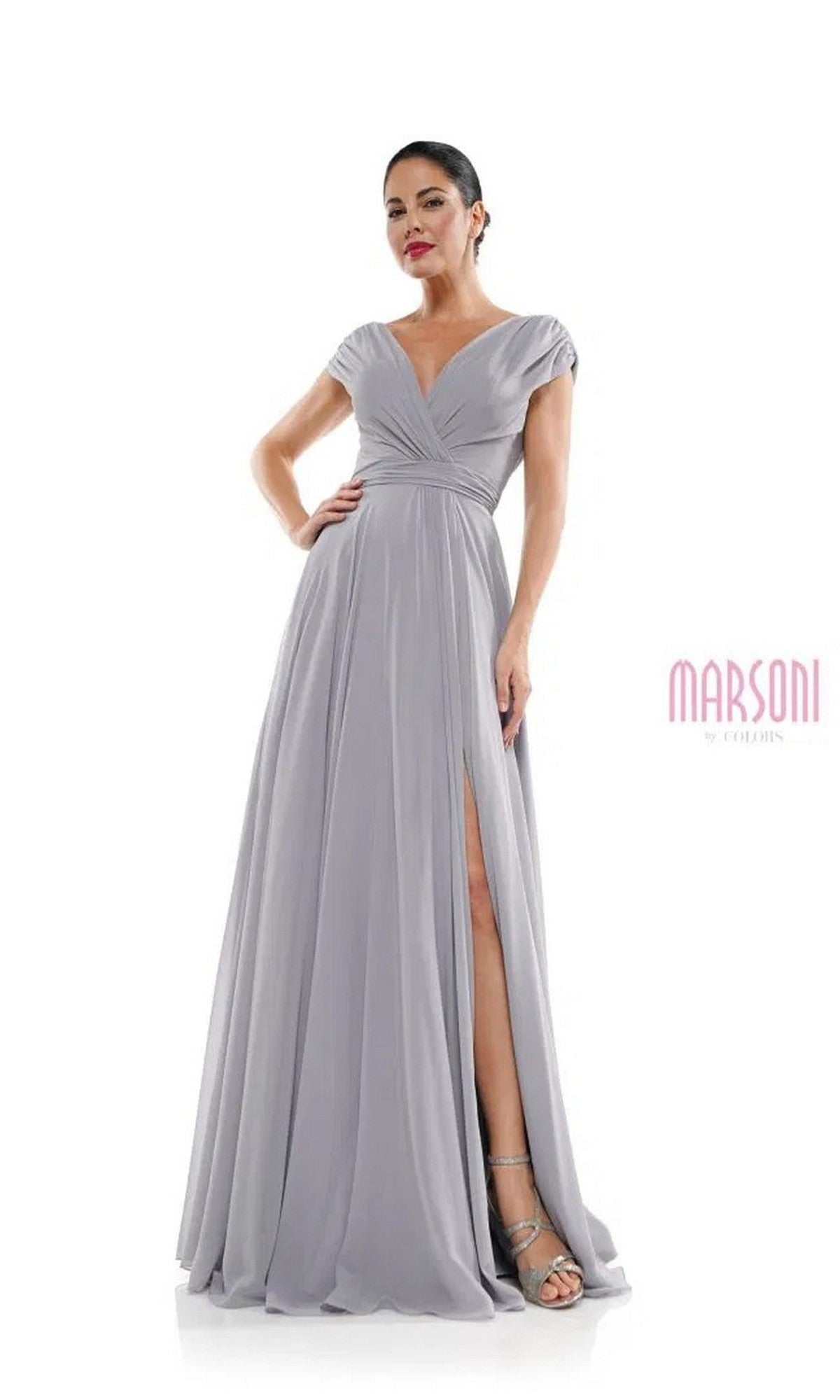 A woman poses against a white background wearing the Marsoni M251 long formal dress, featuring light gray chiffon, cap sleeves, a v-neckline, and a high slit.
